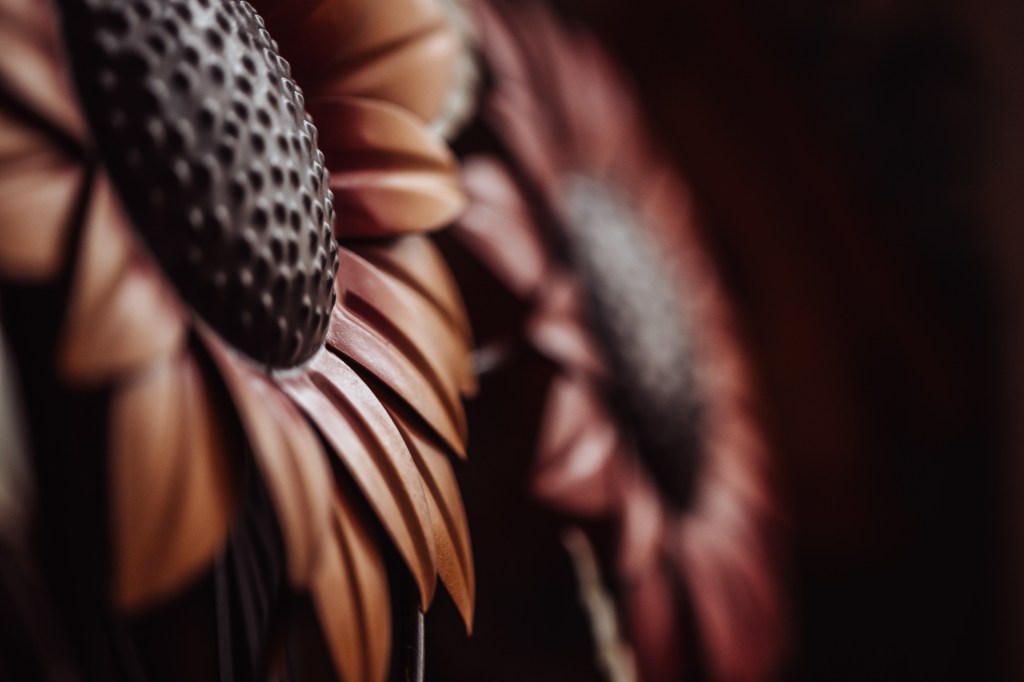 Metal garden art flowers on a dark background. Photo by Tracy Isaacs
