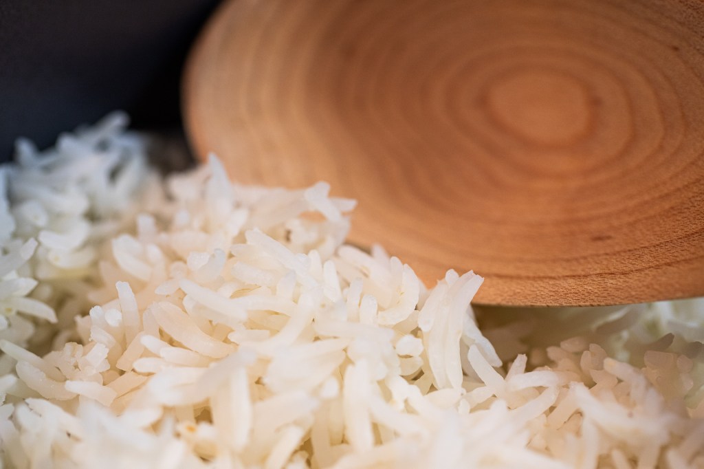 close up of cooked basmati rice with a wooden spoon in the background. Photo by Tracy Isaacs