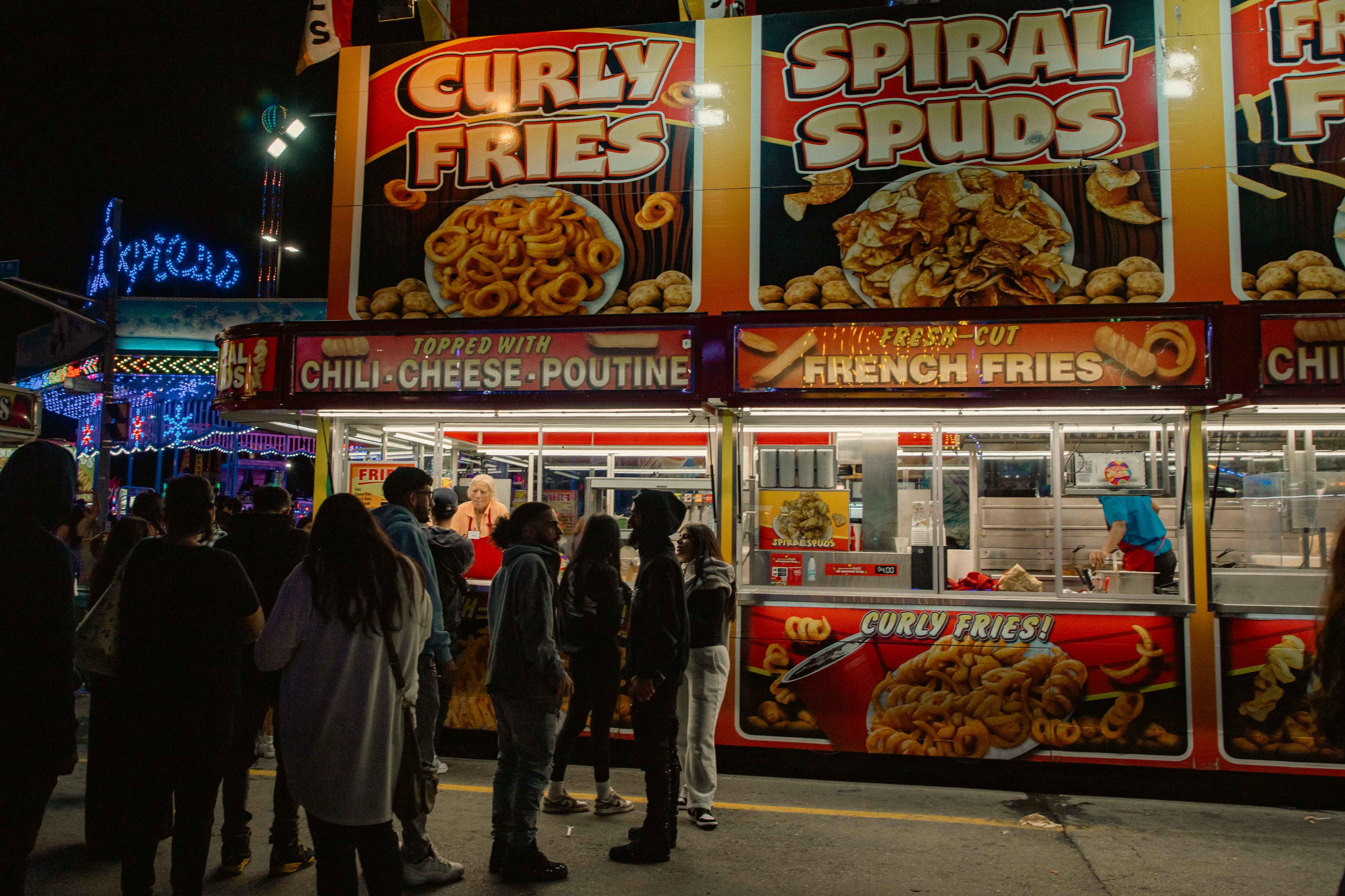 Fries stand at the CNE at night with a crowd of people standing in front. Photo by Tracy Isaacs