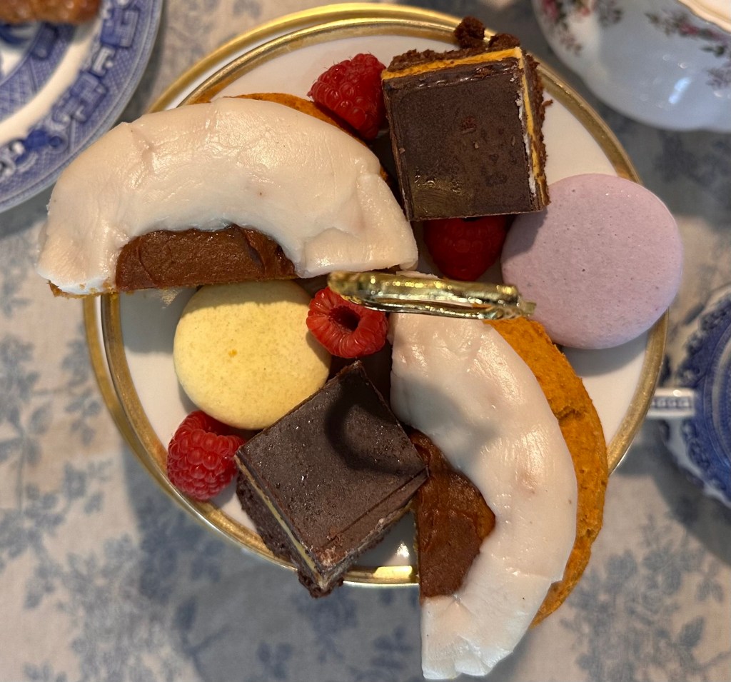 Image description: The top tier from overhead: iced pumpkin scones, nanaimo bars, macarons and fresh raspberries. Photo by Tracy Isaacs (iPhone)
